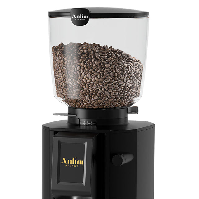 Black coffee grinder with glass container filled with coffee beans on a white background