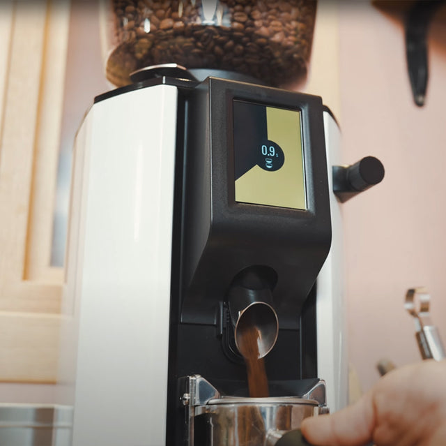 Coffee machine dispensing coffee with a digital display showing '0.9'.