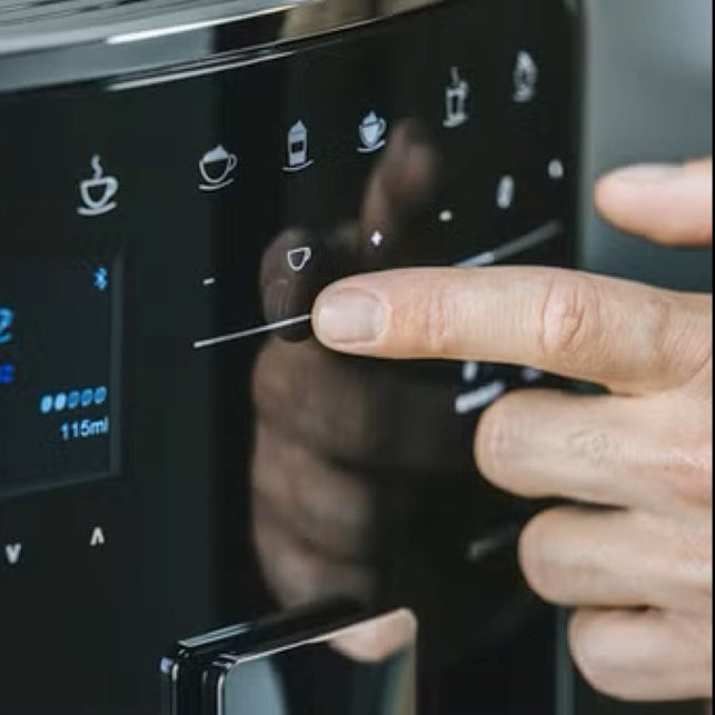Person using a coffee machine with a digital display