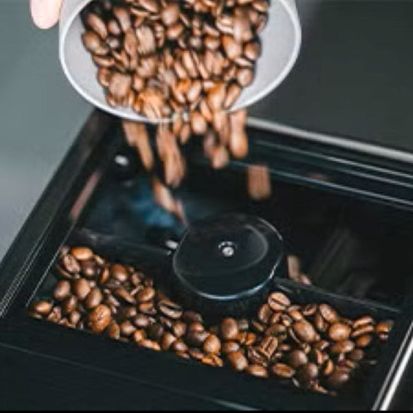 Coffee beans being poured into a coffee grinder