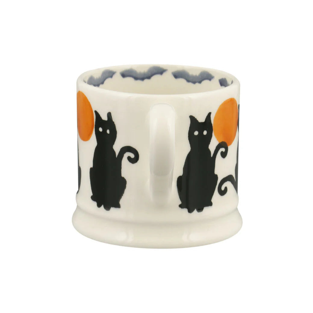 Ceramic mug with black cats and orange moons on a white background