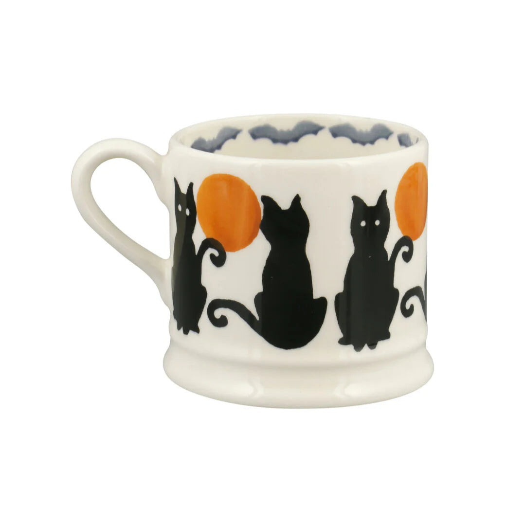 White mug with black cat and orange circle design on a white background