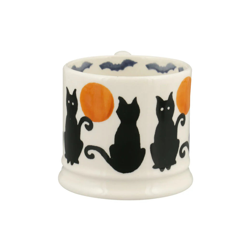 Ceramic mug with black cat and orange moon design on a white background