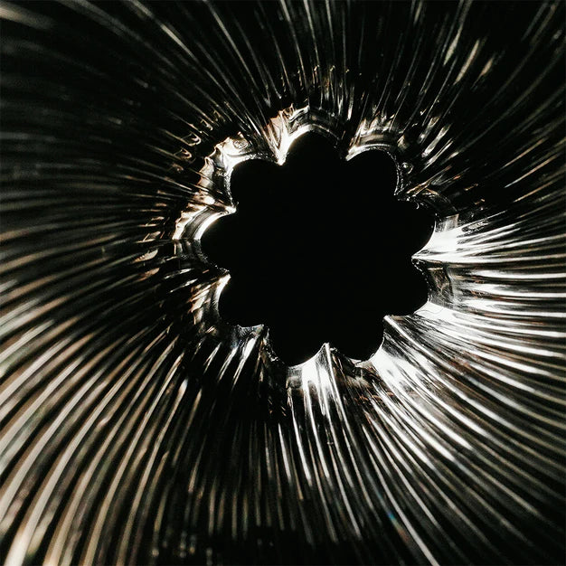 Close-up of a textured glass surface with a central floral design.