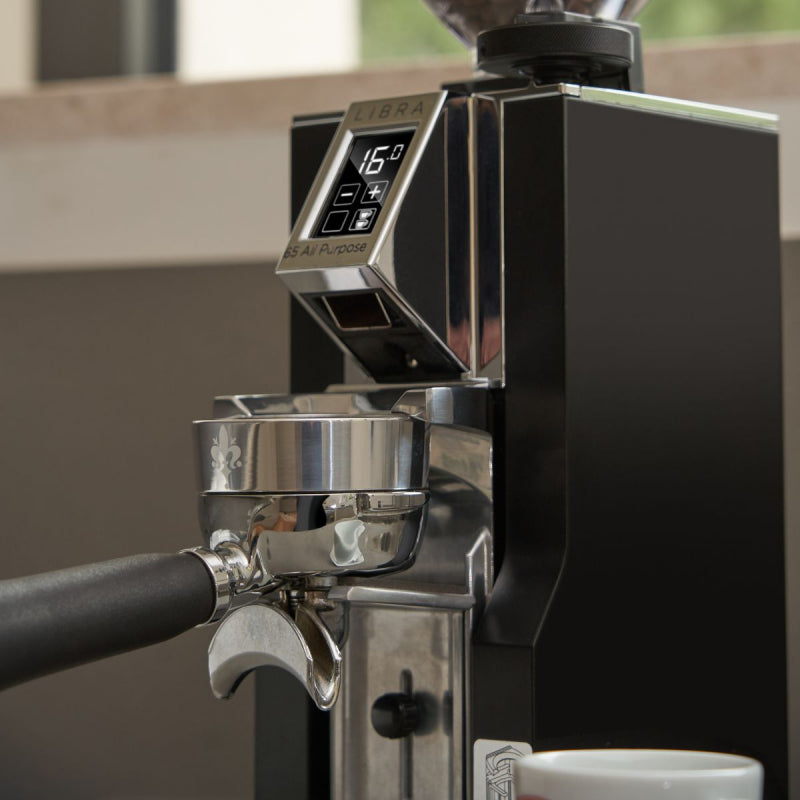 Close-up of a coffee machine with a digital display and brewing portafilter.