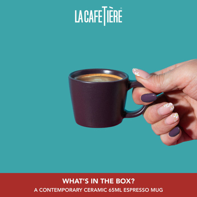 Hand holding a dark espresso mug with La Cafétière branding on a teal background.