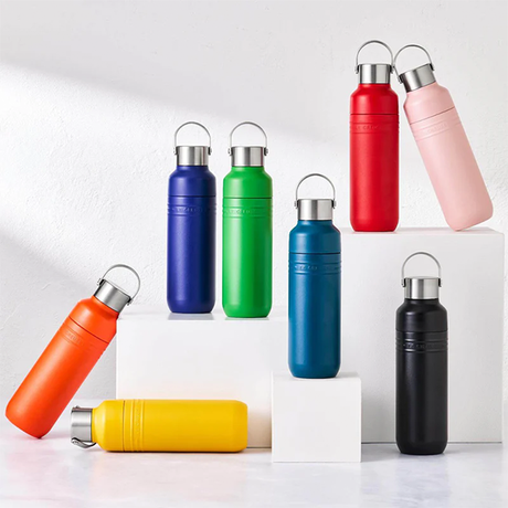 Set of colorful water bottles with metallic caps on a white background