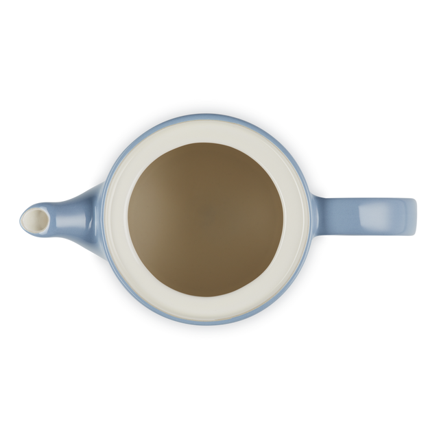 Blue teapot with a white interior on a white background