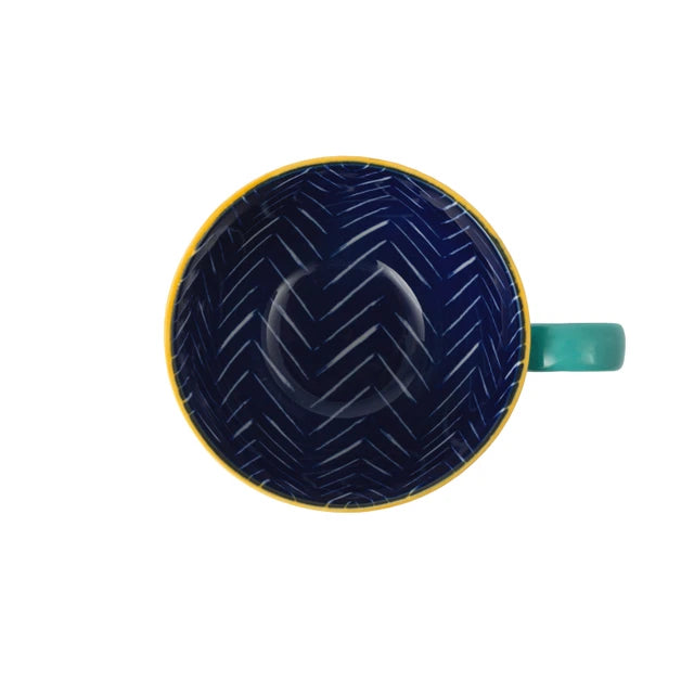Blue mug with yellow rim and handle on a white background