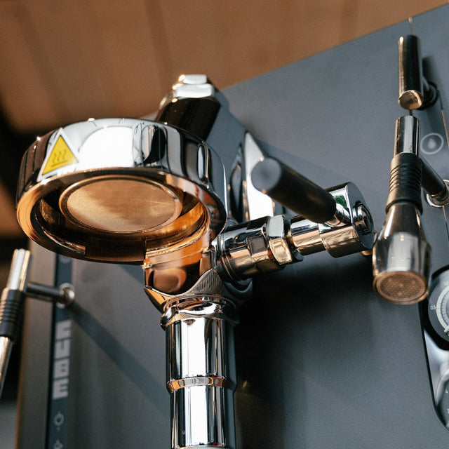 Close-up of a coffee machine's brewing group with various parts.