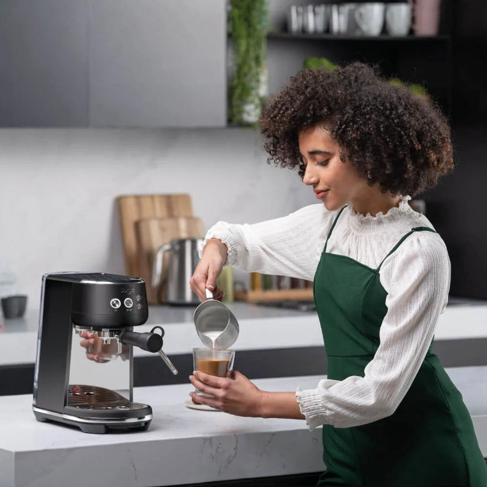 woman preparing a cappuccino with a Sage coffee machine