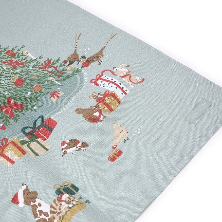 Christmas-themed placemat with reindeer, trees, and presents on a light blue background