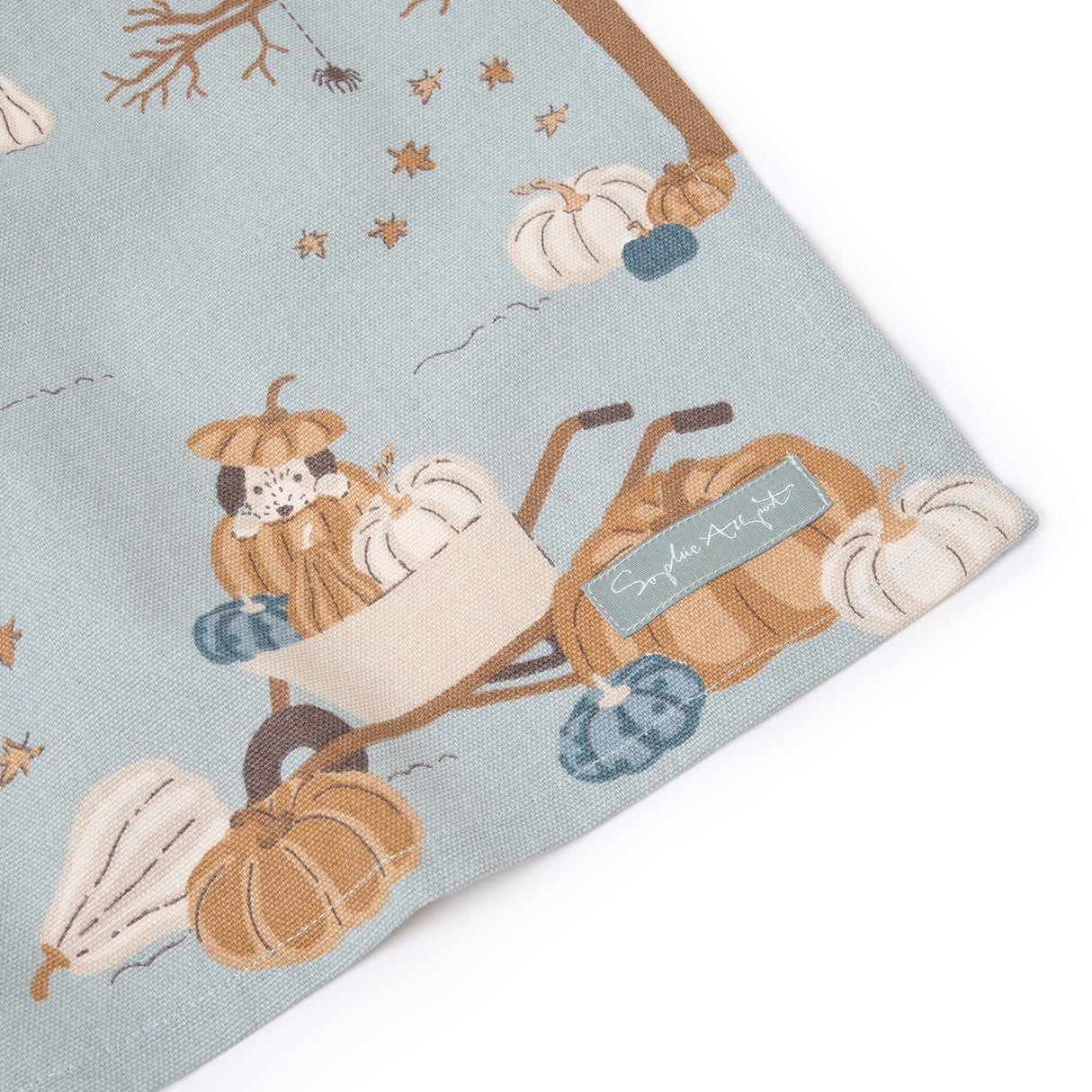 Fabric with pumpkin and wagon design on a light blue background