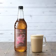 Bottle of Sweetleaf Iced Tea with a glass of iced tea on a wooden surface.