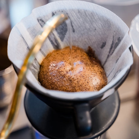 Coffee being poured into a coffee filter with a blurred background