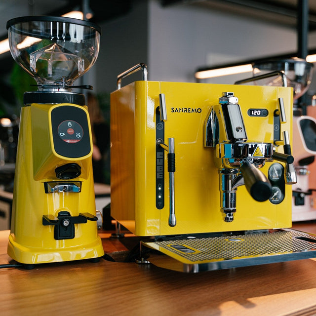 Yellow coffee machine on a wooden counter with blurred background