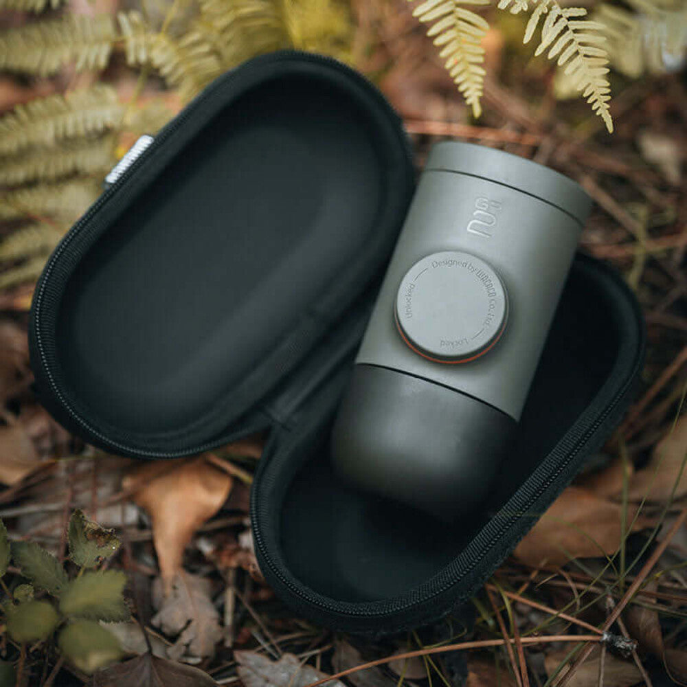 Wacaco Minipresso GR2 in its open protective case on the woodland floor