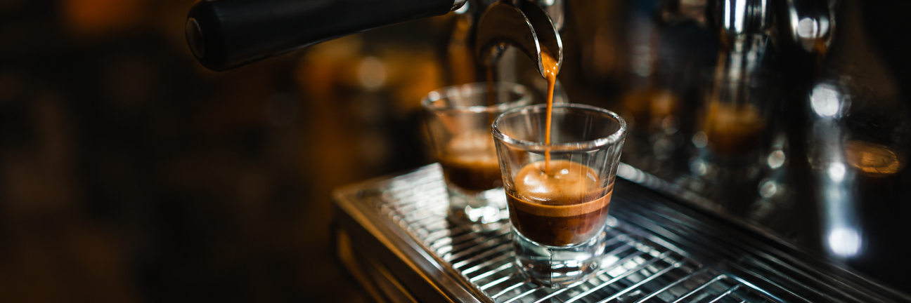 Espresso being poured into a glass with a blurred background