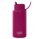 Pink water bottle with a straw lid on a light green background