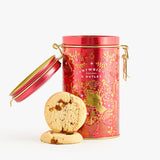 Red decorative cookie tin with gold accents and cookies on a white background