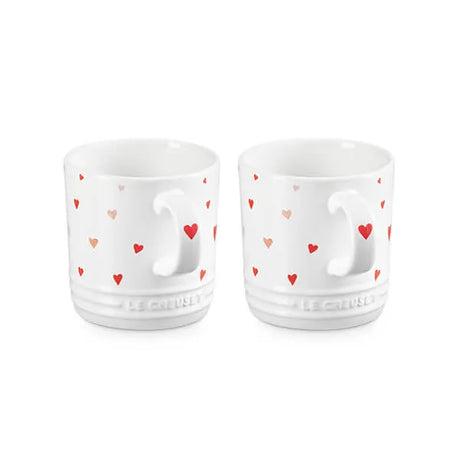 Le Creuset Stoneware Set of 2 Heart Mugs 350ml Two white ceramic cups with heart patterns on a white background
