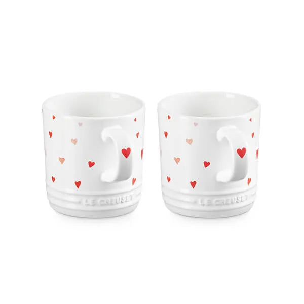 Le Creuset Stoneware Set of 2 Heart Mugs 350ml Two white ceramic cups with heart patterns on a white background