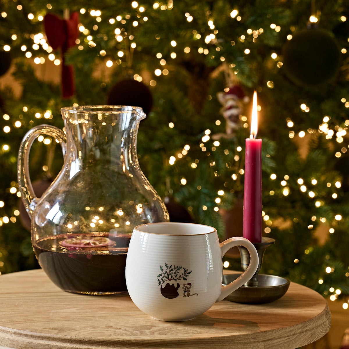 Sophie Allport Christmas Puddings mug on a tray beside a glass jug, candle and Christmas tree