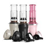 Aeropress coffee makers in beige, black, and pink on a white background