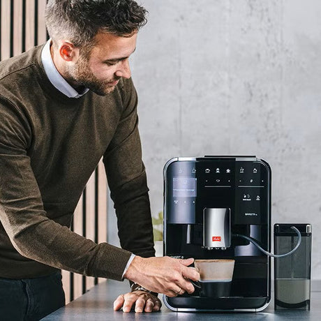 Man using a coffee machine in a kitchen setting