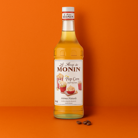 Bottle of Monin Pop Corn syrup on an orange background