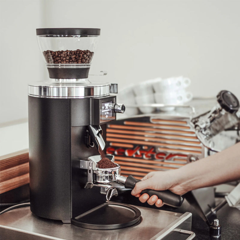 Coffee grinder with coffee beans on a kitchen counter