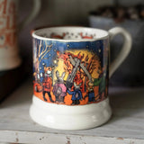 Mug with a colorful illustration of people around a campfire on a wooden surface.