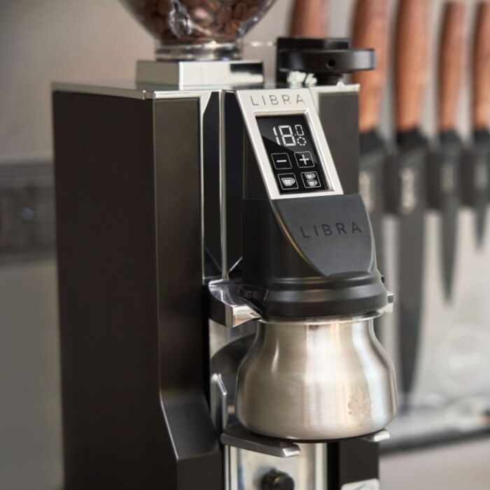 Coffee grinder with digital display and 'Libra' branding in a kitchen setting.