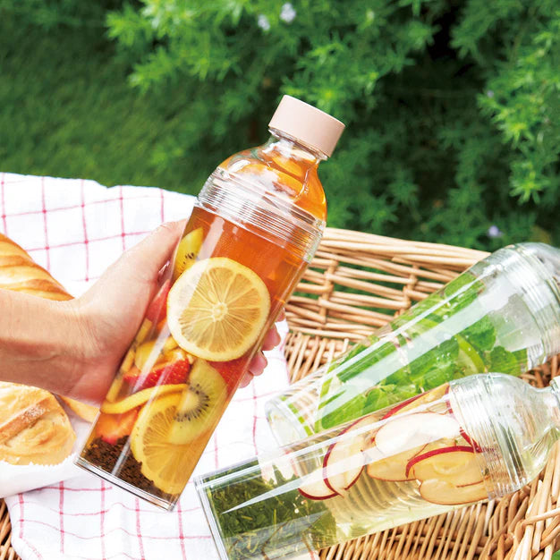 Bottles of fruit-infused drinks with a picnic setting