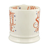 White mug with colorful text and star designs on a white background