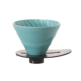 Teal coffee filter with black base on a white background