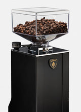 Black coffee grinder with clear container filled with coffee beans on a white background