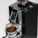 Coffee grinder with digital display and coffee beans being ground