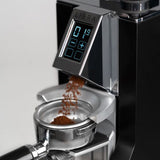 Coffee grinder with digital display and coffee beans being ground
