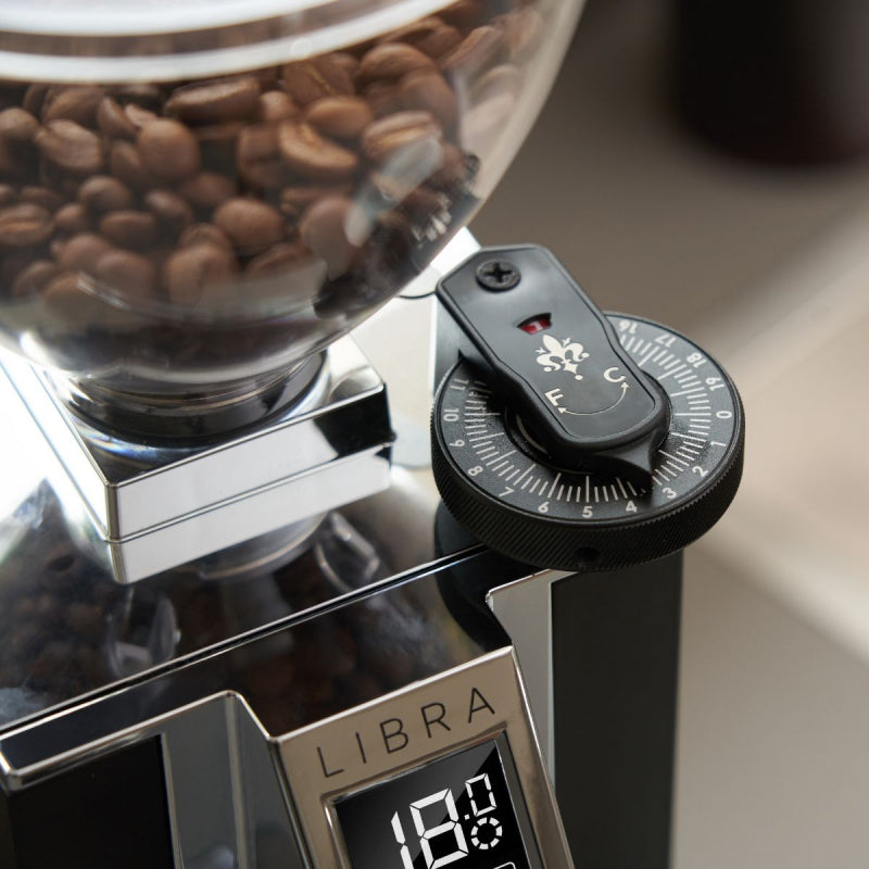 Coffee grinder with coffee beans and digital display on a light background
