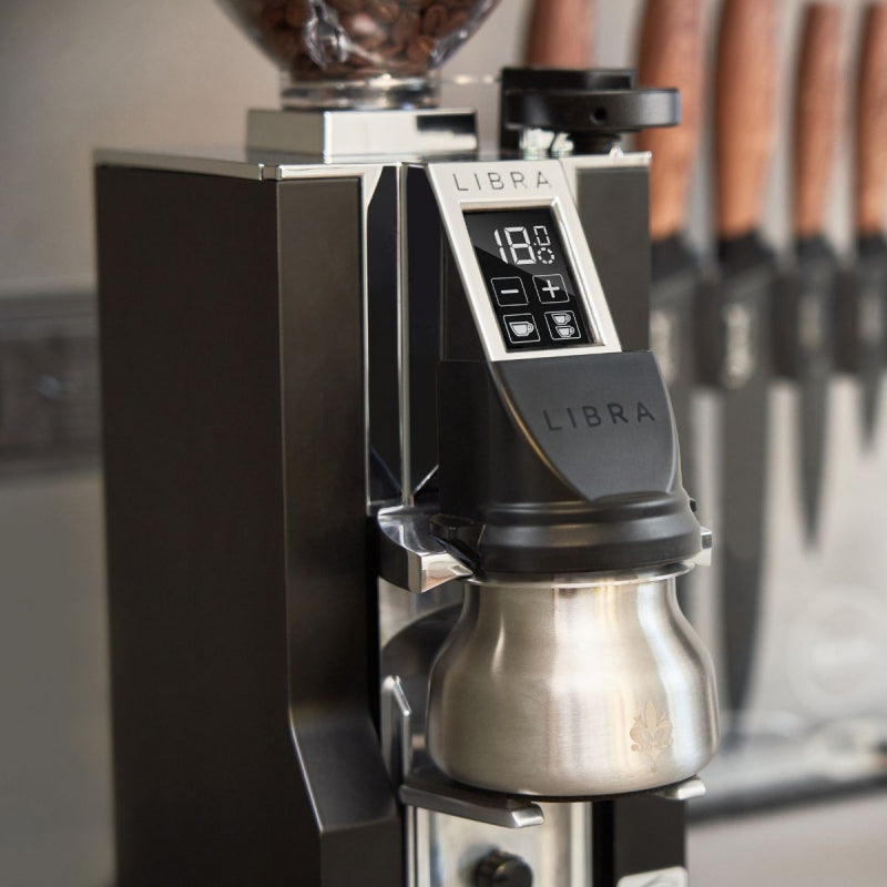 Coffee brewing device with digital display and 'Libra' branding in a kitchen setting.