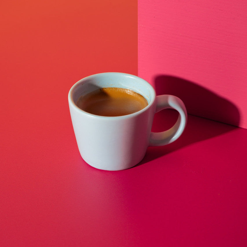 White coffee cup with a yellow and red background