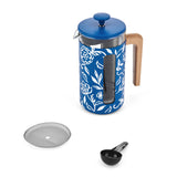 Blue floral-patterned French press coffee maker with wooden handle and accessories on a white background