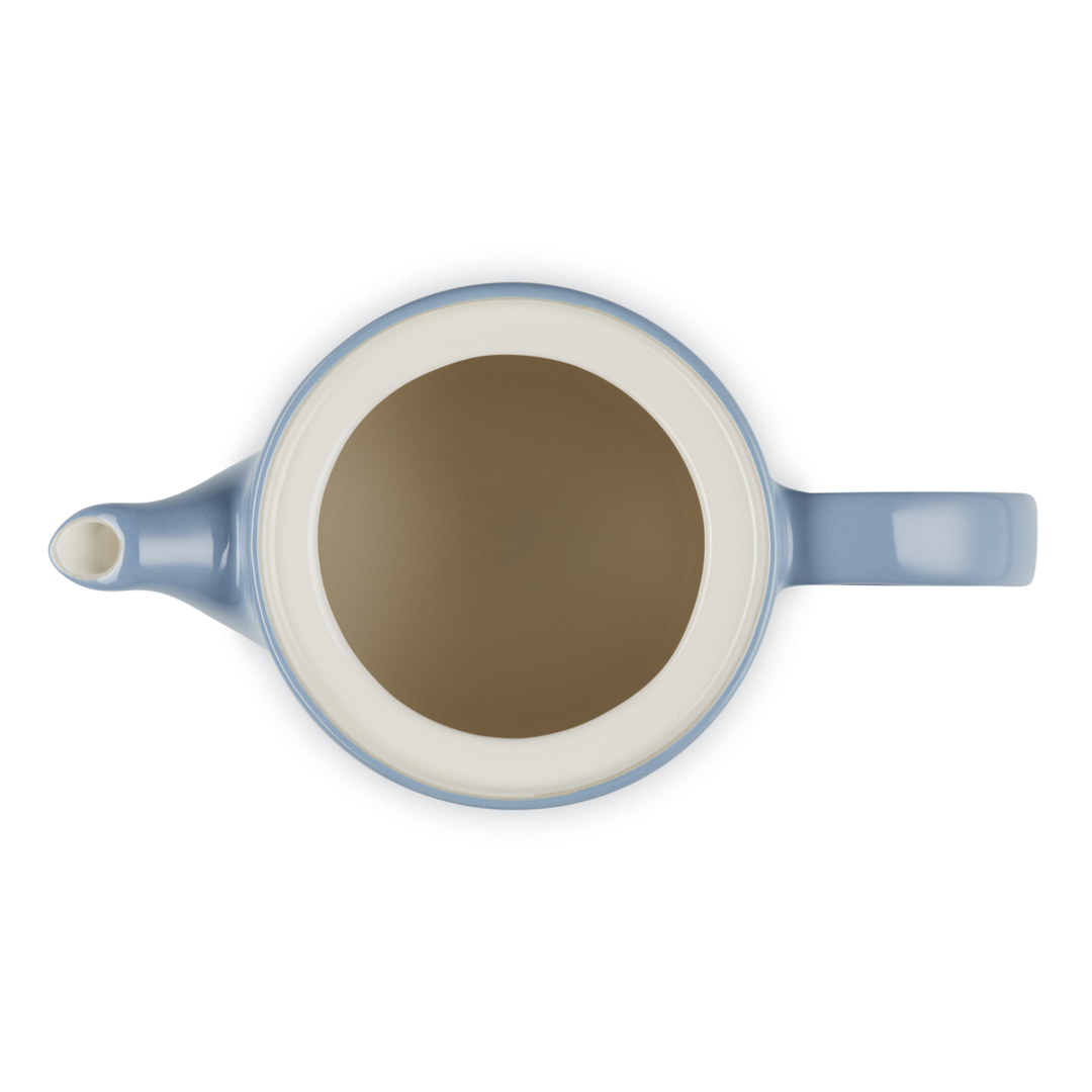 Blue teapot with a white interior on a white background