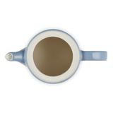 Blue teapot with a white interior on a white background