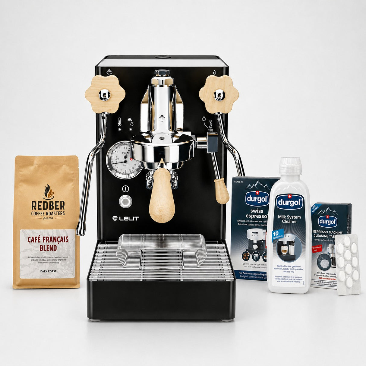 Espresso machine with coffee beans, cleaning products, and packaging on a white background