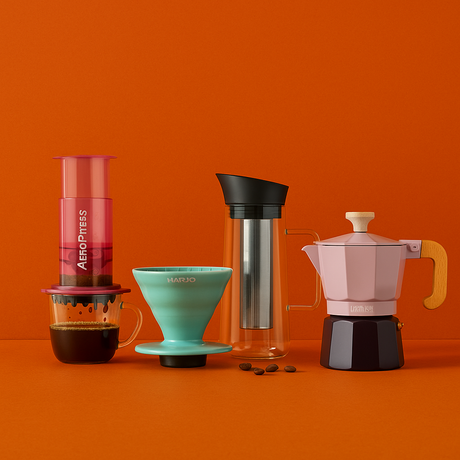 Collection of coffee brewing devices on an orange background