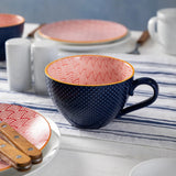 Ceramic tableware with blue and pink patterns on a kitchen counter.