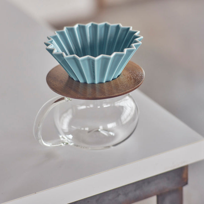 Blue ceramic filter on a wooden stand with a glass base on a blurred background