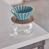 Blue ceramic filter on a wooden stand with a glass base on a blurred background
